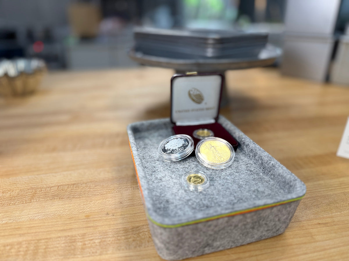 Diverse investment grade US gold and silver coin collection in protective capsules displayed in organized coin binder American Eagle Buffalo and commemorative issues