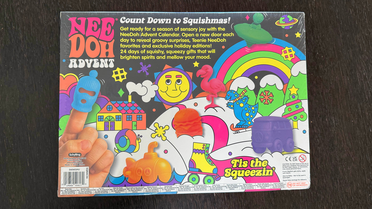 Nee Doh Advent 'Tie the Squeezin'' toy box on a dark wood background. The packaging is highly colorful with cartoon graphics including a rainbow, smiley face, planets, and a hand pressing a blue squishy button.